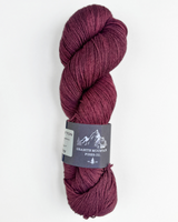 Burgundy skein of yarn with a label on a white background
