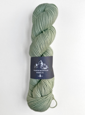 Skein of green yarn with a label on a white background