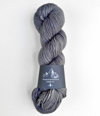 Gray skein of yarn with a label on a white background
