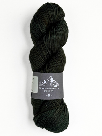 Dark green skein of yarn with a label on a white background