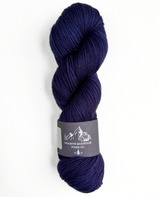 Indigo skein of yarn with a label on a white background