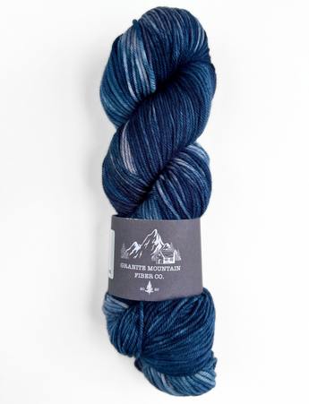 Blue skein of yarn with a label on a white background