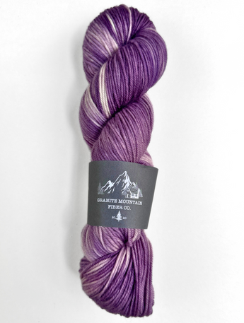 Purple skein of yarn with a label on a white background