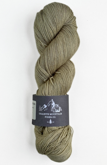 Green skein of yarn with a label on a white background