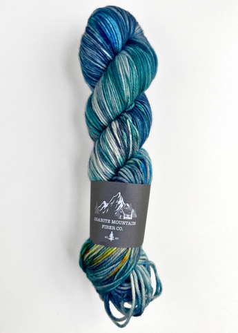 Blue and green skein of yarn with a label on a white background