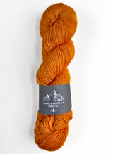 Orange skein of yarn with a label on a white background