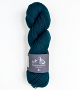 Teal skein of yarn with a label on a white background