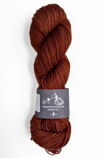 Blue skein of yarn with a label on a white background