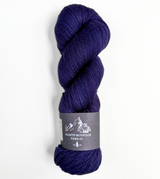 Purple skein of yarn with a label on a white background
