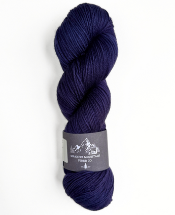Indigo skein of yarn with a label on a white background