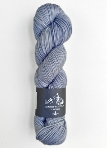 Blue skein of yarn with a label on a white background