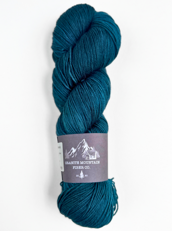 Blue skein of yarn with a label on a white background