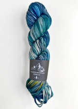 Blue and green skein of yarn with a label on a white background